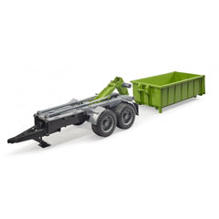 Green and gray Bruder hook lift trailer with tilting trough, featuring realistic wheels and detailing.