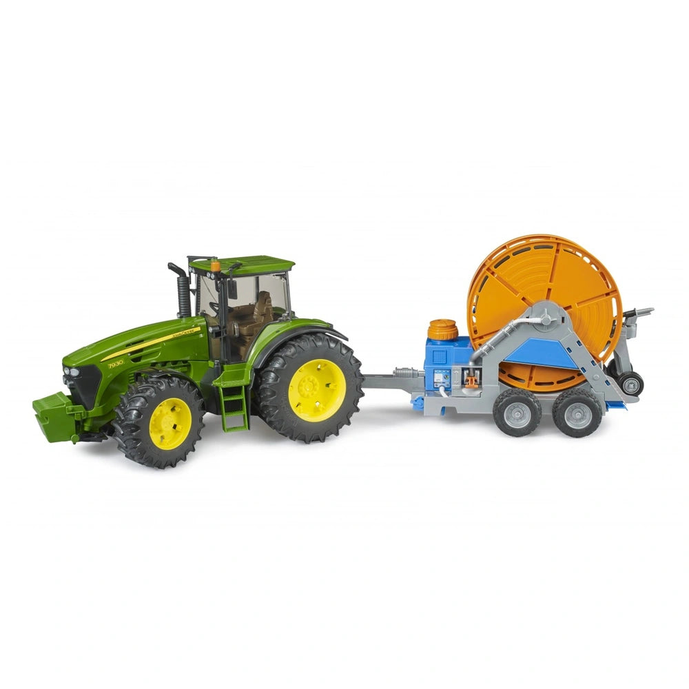 Green tractor with large tires towing an orange hose reel irrigation trailer by Bruder.