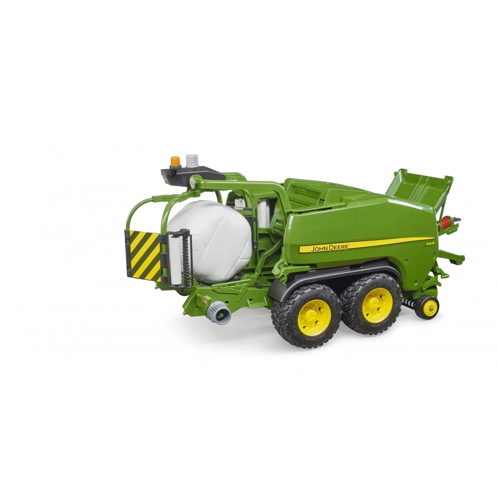 Green BRUDER John Deere C441R toy baler with yellow wheels and detailed machinery elements, including a bale in progress.