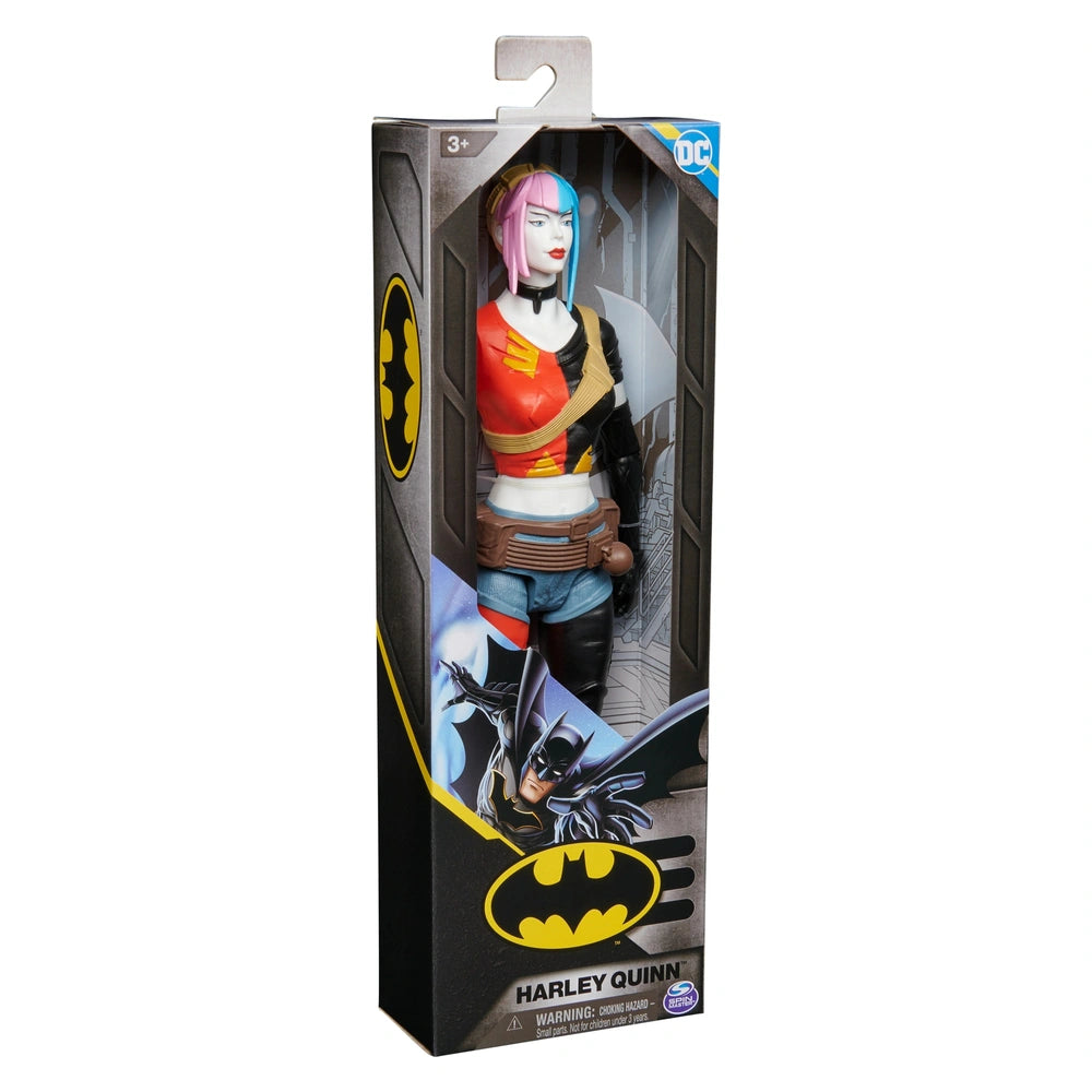 Harley Quinn action figure in a black and yellow package, featuring pink hair and a red top, holding a weapon.