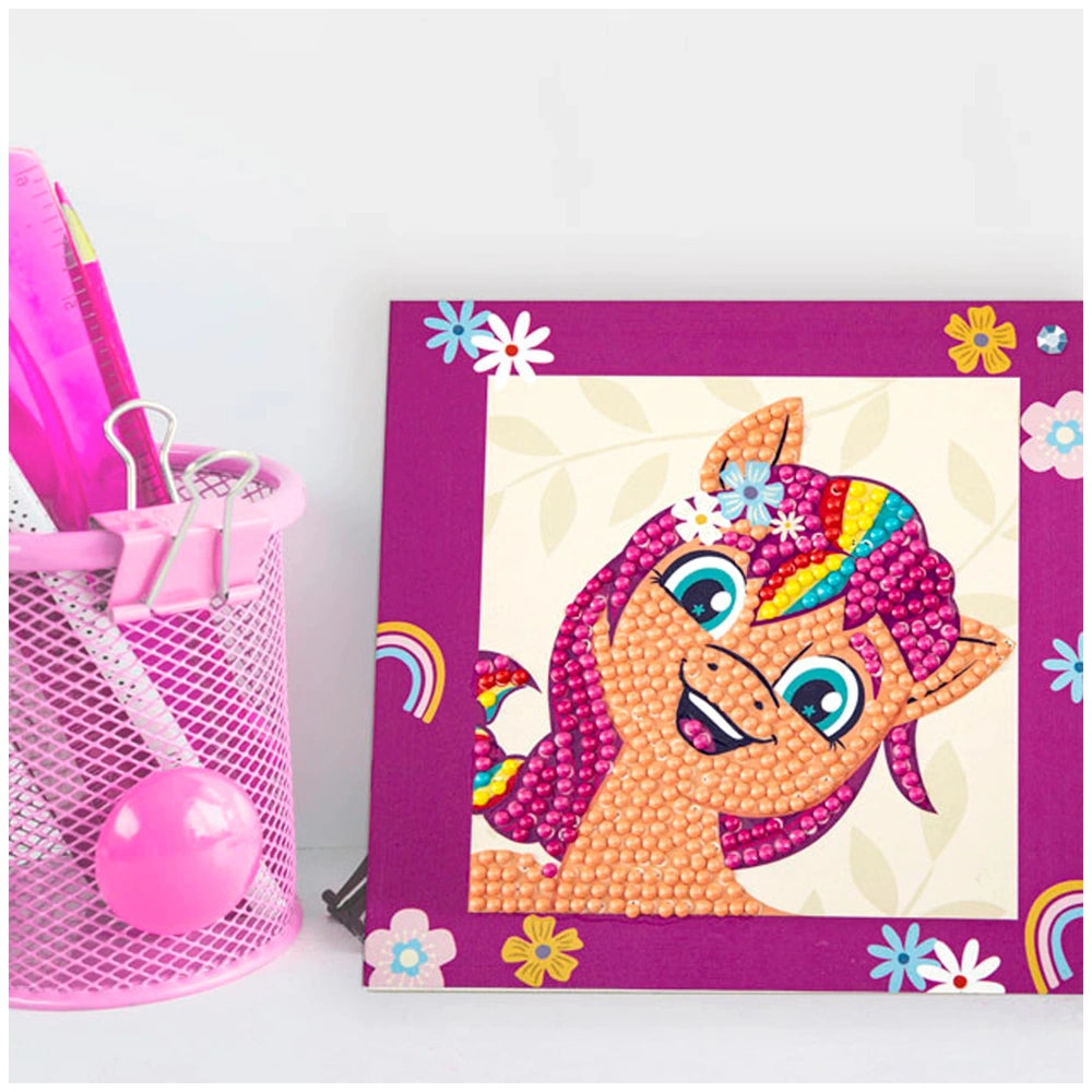 DIAMOND DOTZ Dotzies craft kit featuring a pink basket, pink ball, and purple pony frame in a retail packaging view.