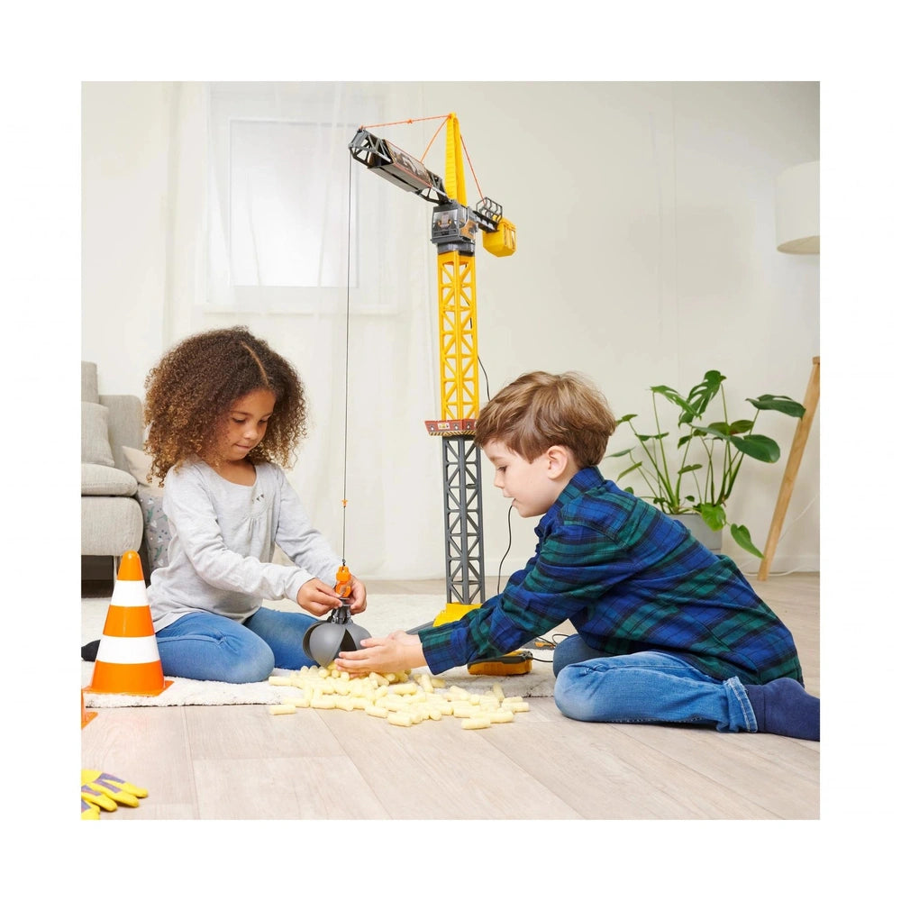 Dickie Mighty Crane Play Vehicle with two children playing on a wooden floor, one holding a yellow and black toy crane.