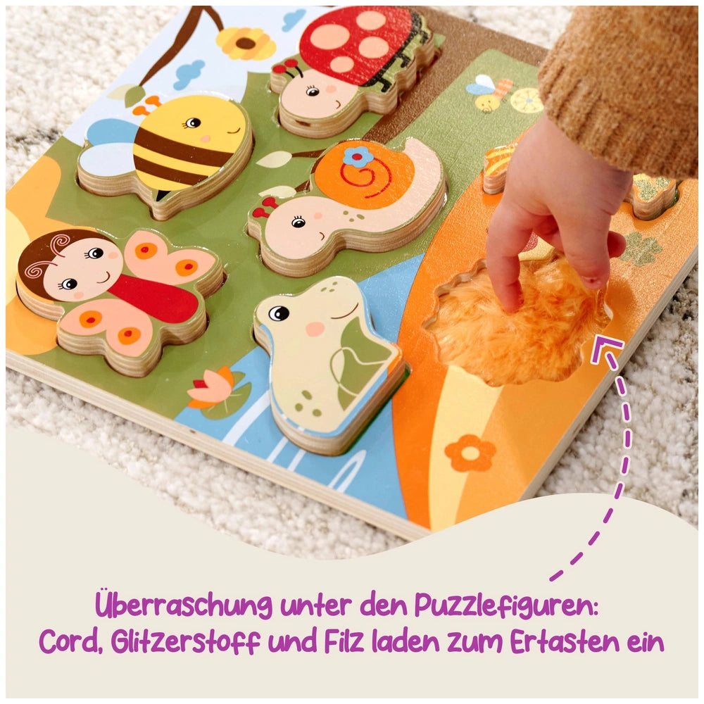 Colorful wooden Bee-Happy sensory puzzle with various animal shapes, held by a childs hand on a light carpet.