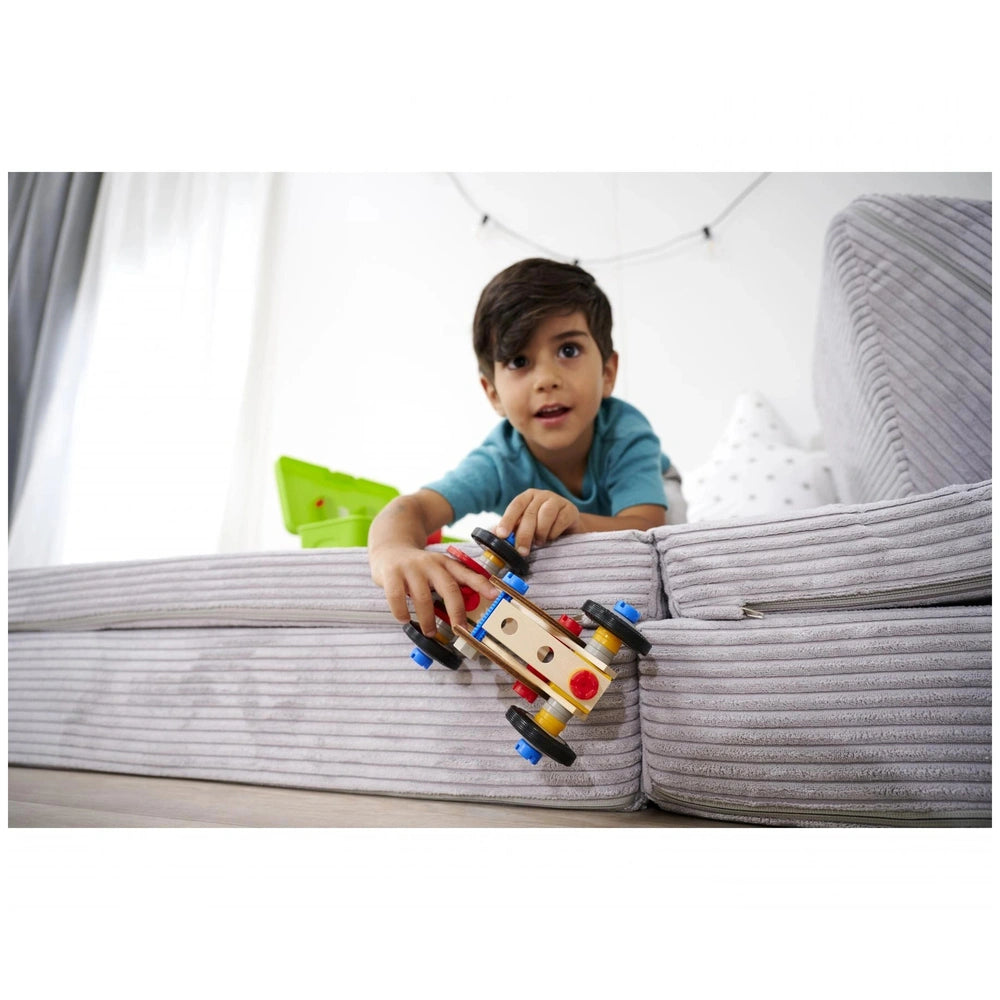 Eichhorn Constructor Racer Car is held by a young boy in a blue shirt, sitting on a grey sofa with a white background.