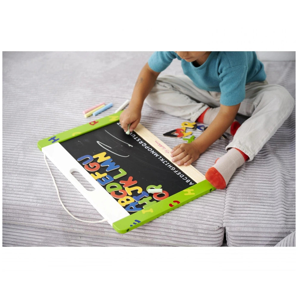 Eichhorn Magnetic and Chalkboard: Child seated with colorful magnetic letters, crayons, and a book in a playful setting.