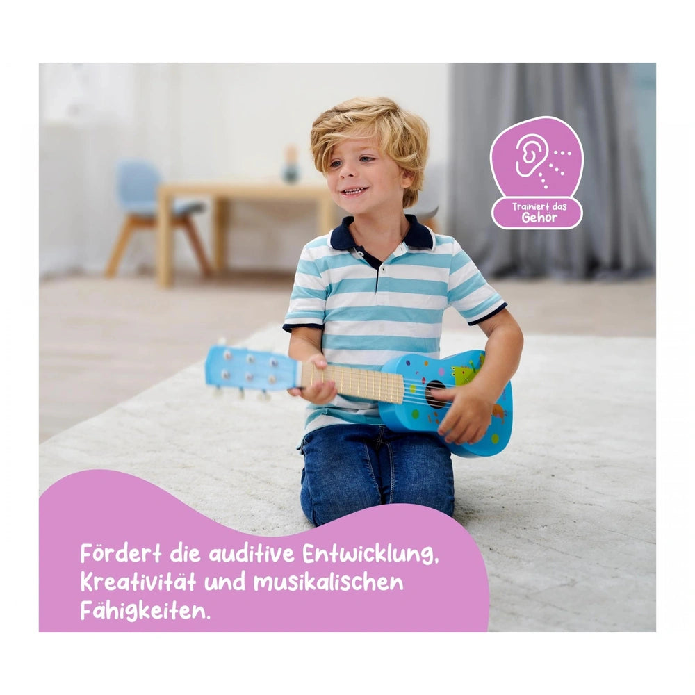 Eichhorn Music Wooden Guitar 54cm in blue, featuring a child playing and promoting auditory development in a cozy indoor sett