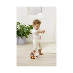 Eichhorn Pull Back Hedgehog toy displayed with a child playing on a light wooden floor in a minimalist room.