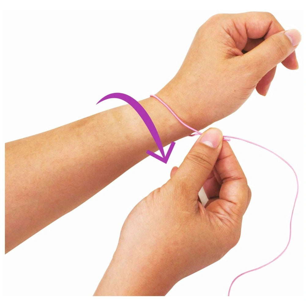 Eichhorn Wooden Bead Set with a close-up of a hand tying pink string around a wrist against a plain white background.