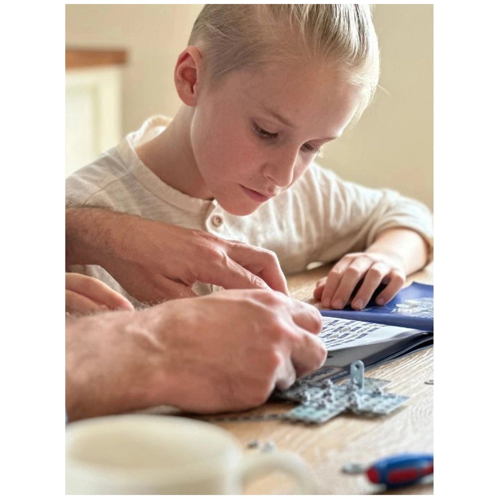 Eitech Motorcycle construction set on a wooden table with a child and adult interacting closely.