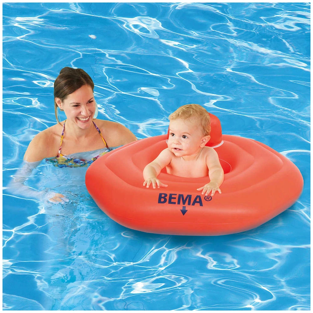 Happy People Bema Baby Swimming Seat with a baby in a red inflatable ring, smiling in clear blue water with a woman.