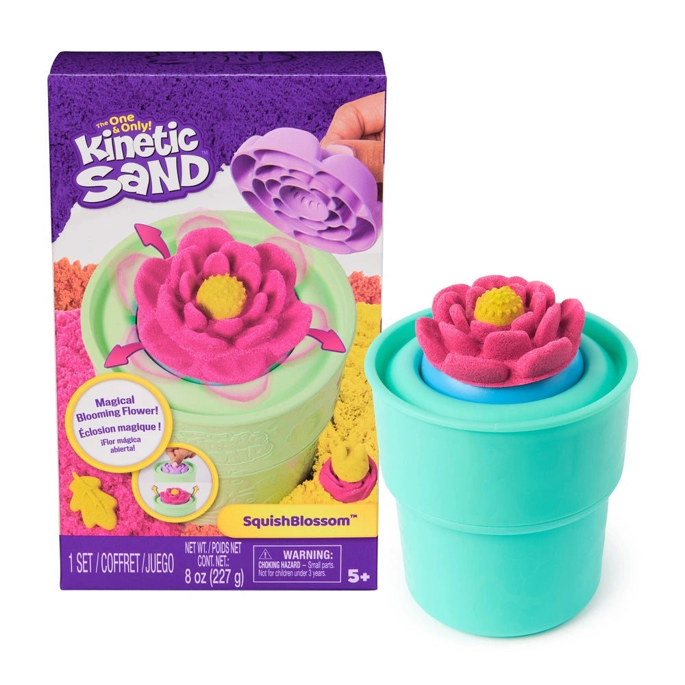 Kinetic Sand Squish Blossom features a green container with a pink fuzzy flower design and a blue lid, set against purple pac