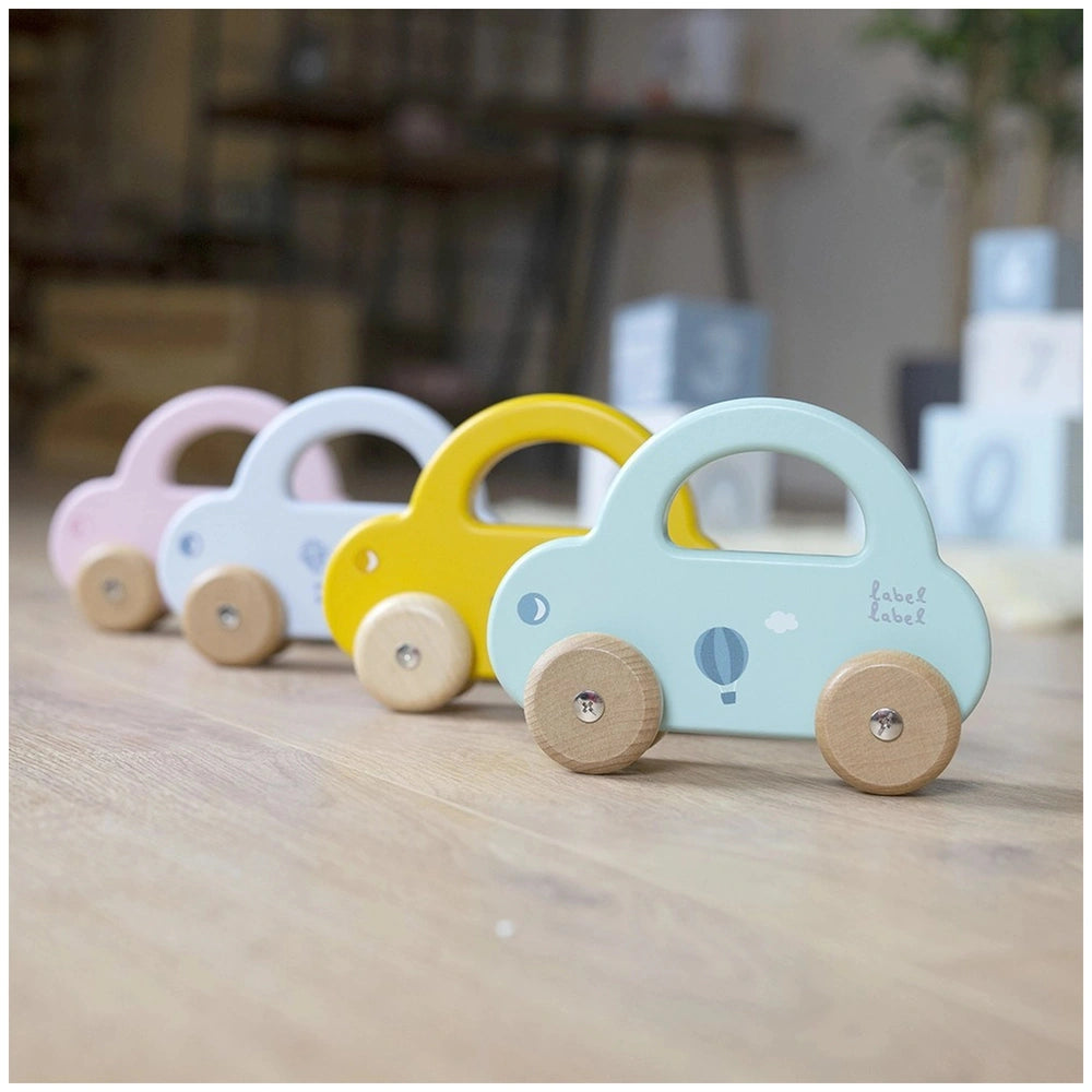 Blue, yellow, pink, and white wooden push and pull toy cars with four wheels arranged centrally.