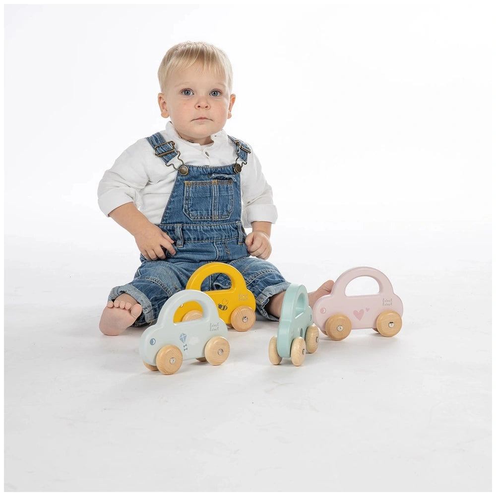 Label-Label Little Car push and pull toy set with a child in blue overalls holding a yellow steering wheel next to colorful c