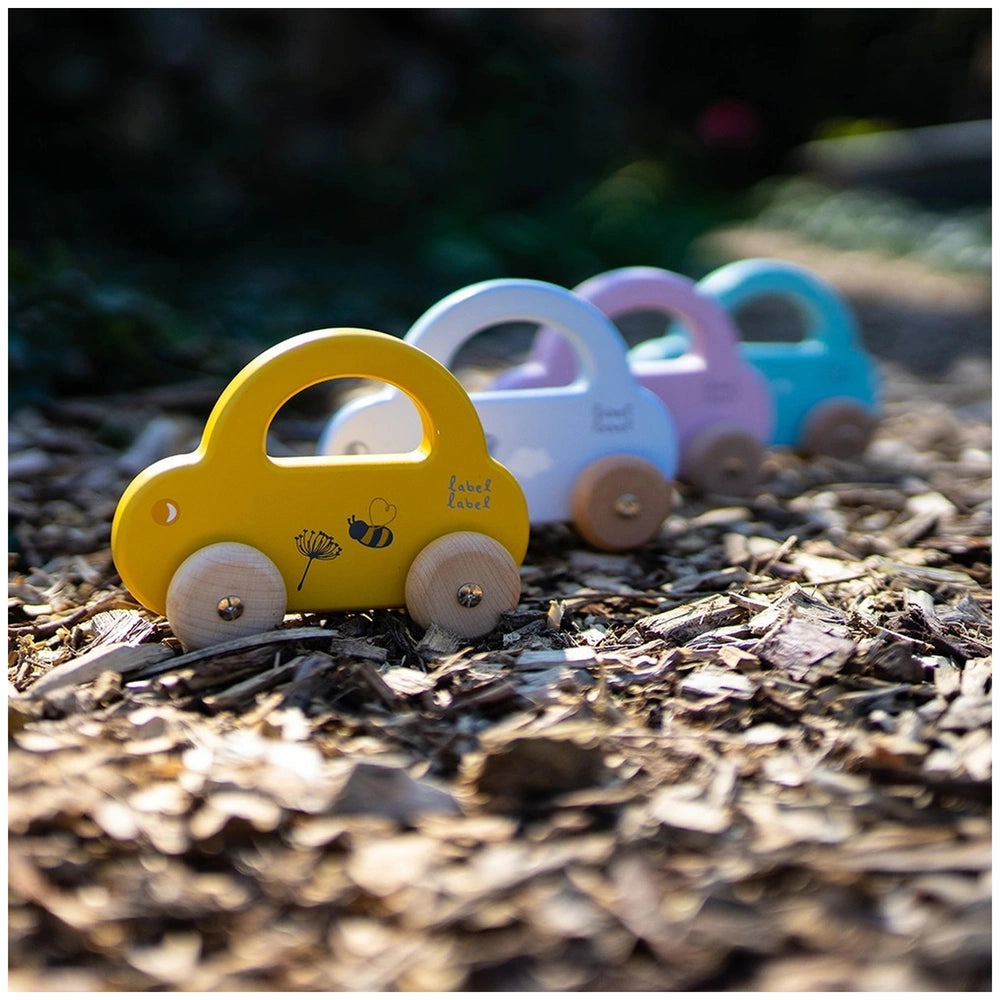 Yellow push and pull toy car with wooden wheels, featuring "label" text on a matte plastic surface.