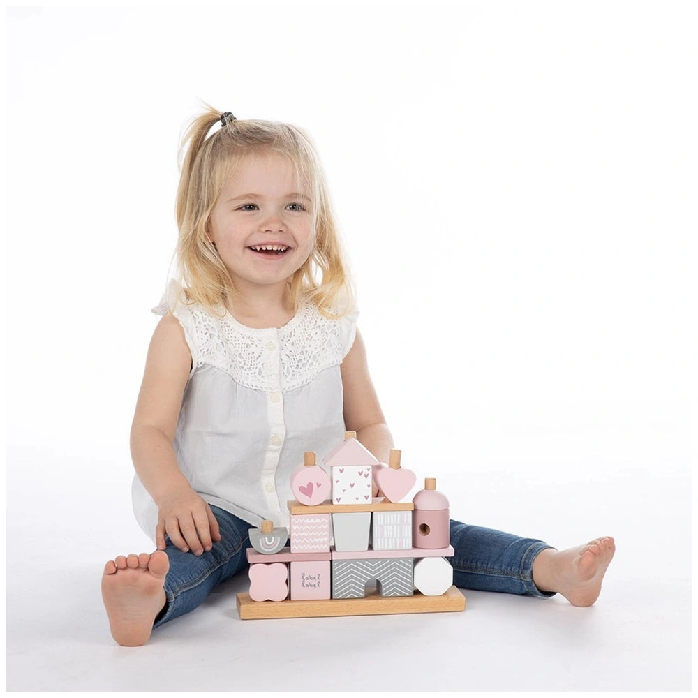 Label-Label stacking blocks house held by a young girl in a white blouse, showcasing various patterned compartments on a whit