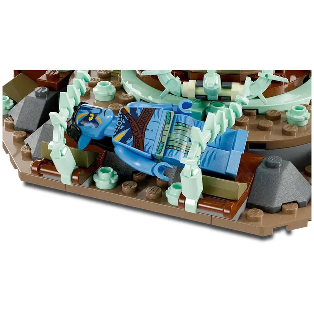 Detailed LEGO Avatar construction set featuring a blue minifigure of Jake Sully lying on a rocky base, surrounded by green plant elements.