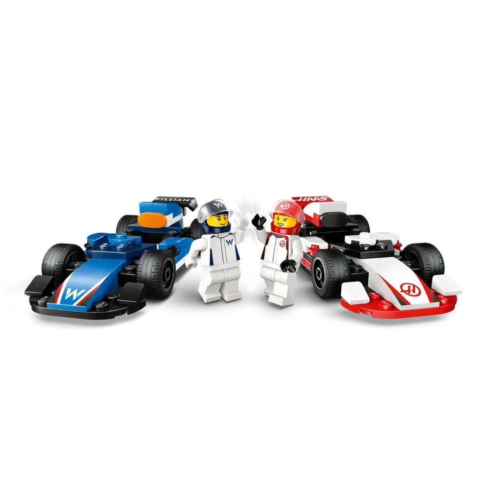 Two LEGO race cars, one blue for Williams and one red for Haas, with mini-figures in racing suits standing between them, smiling and waving.