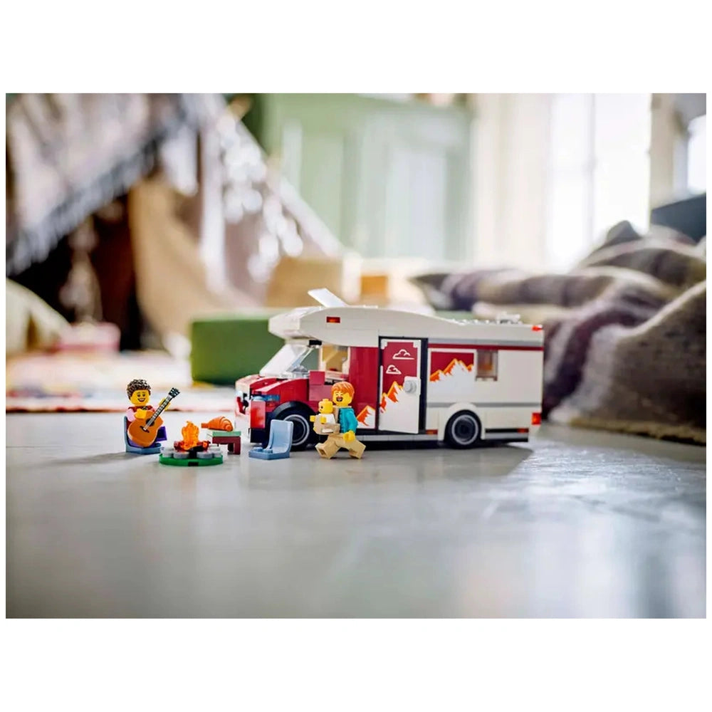 LEGO City Holiday Adventure Camper Van set with two minifigures by a campfire, one playing guitar, enjoying an outdoor scene.