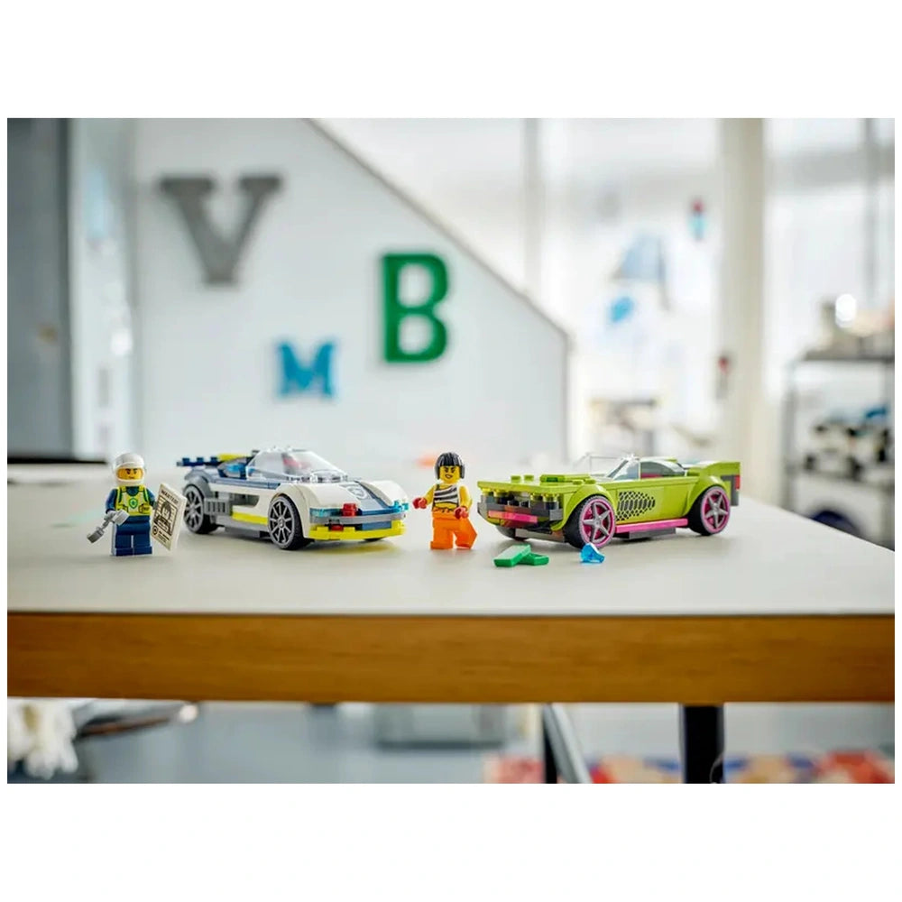 LEGO® City Police Car and Muscle Car Chase set featuring a white police car and a green muscle car, with two minifigures on a table.