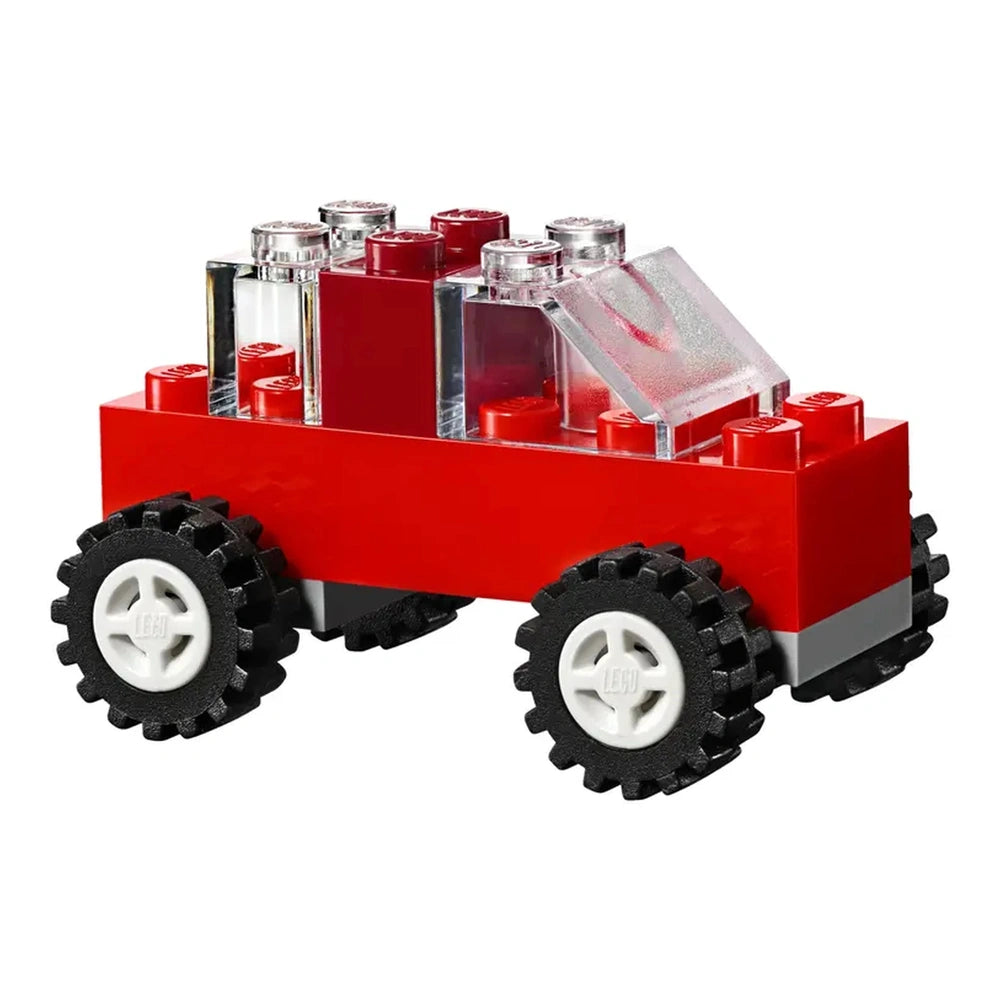 Red LEGO® car toy featuring a clear windshield, black tires, and colorful brick details, perfect for imaginative play.