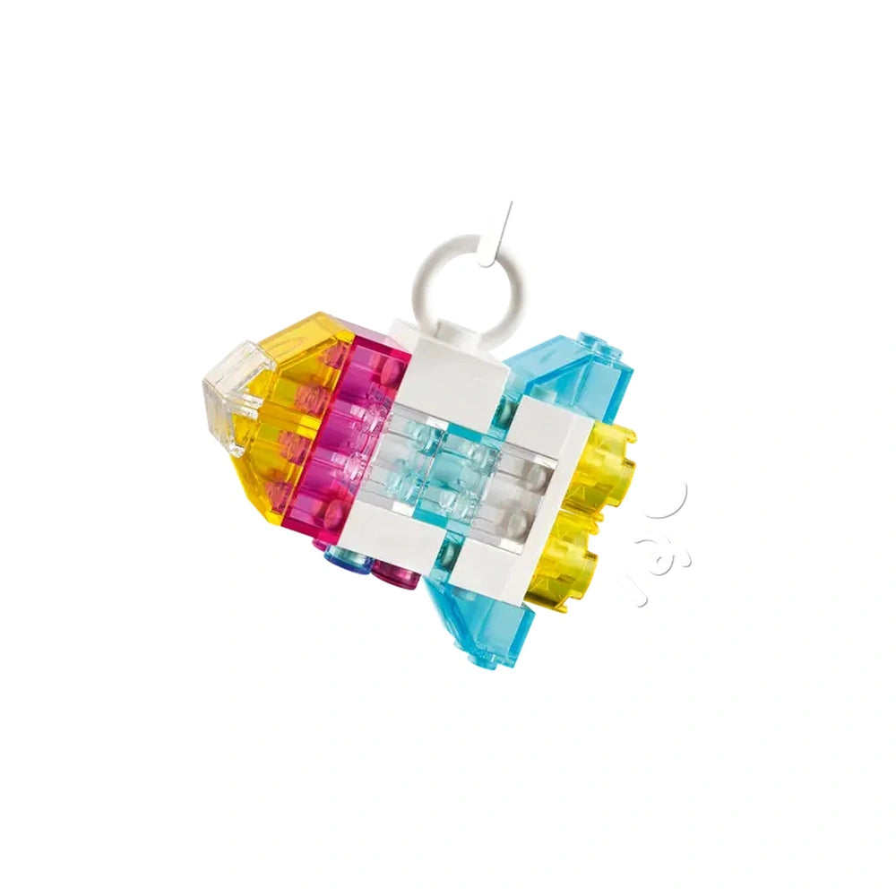 Colorful LEGO® rocket model made of transparent and solid bricks, featuring pink, yellow, and blue elements for imaginative play.