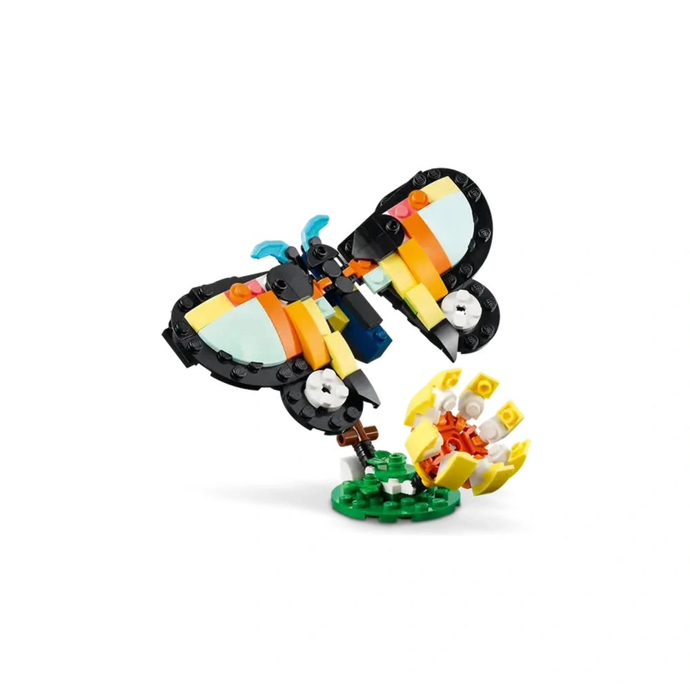 Colorful LEGO butterfly with intricate wings, perched on a green base, surrounded by vibrant flowers.