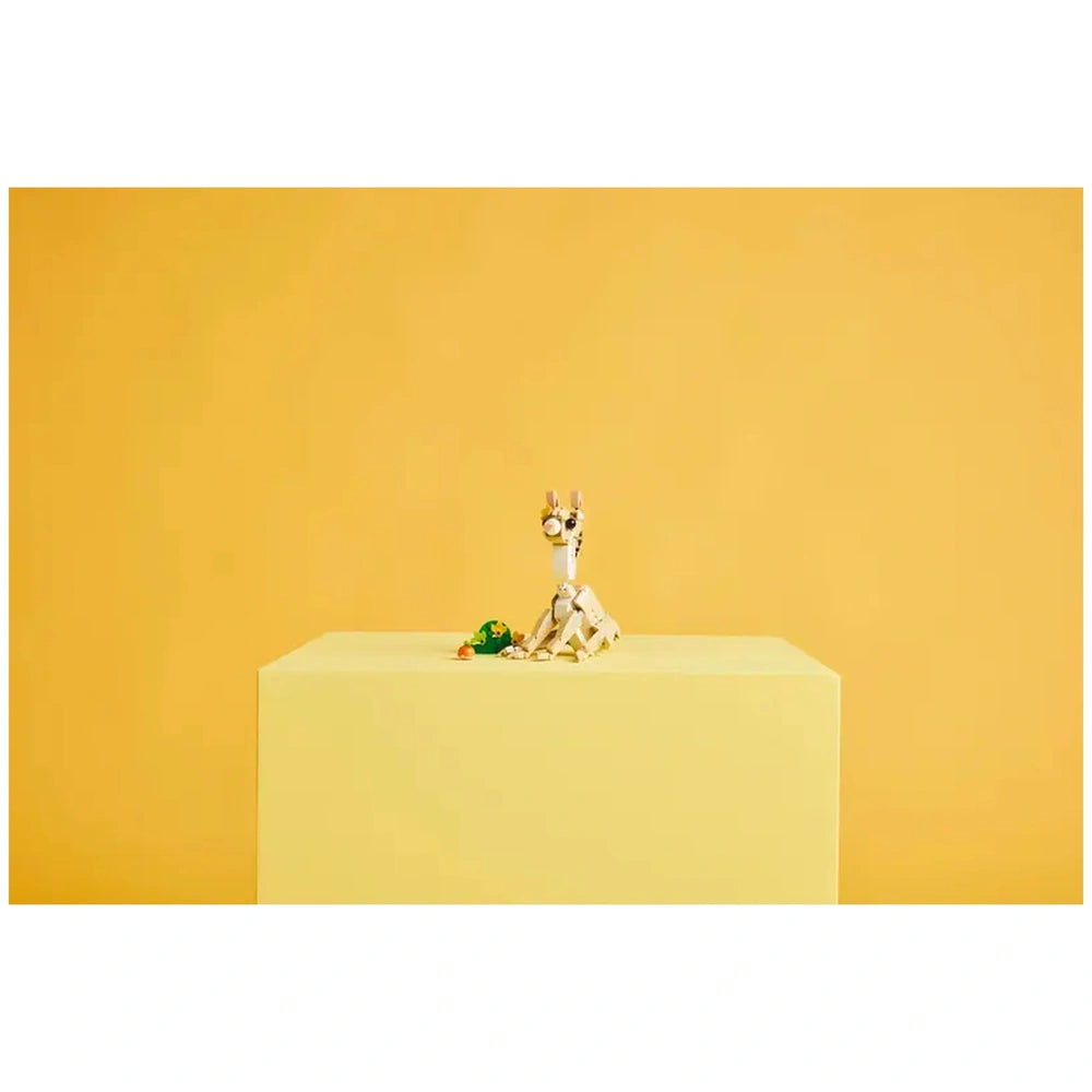 LEGO Creator Cute Bunny construction set displayed on a light yellow pedestal, featuring a posable bunny, a carrot, and a patch of green grass.