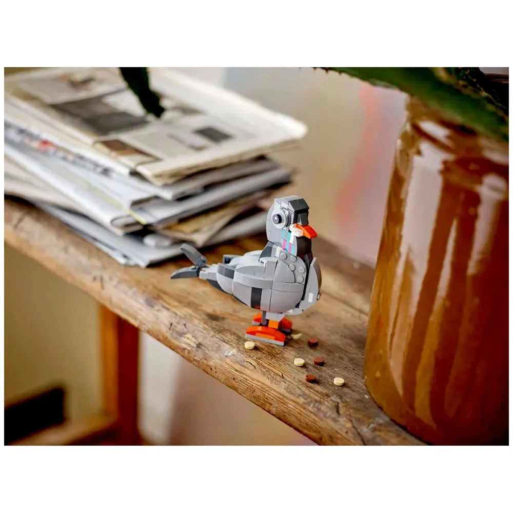 LEGO® Creator 3in1 playful cat set displayed on a wooden surface, surrounded by scattered colored pellets and magazines.