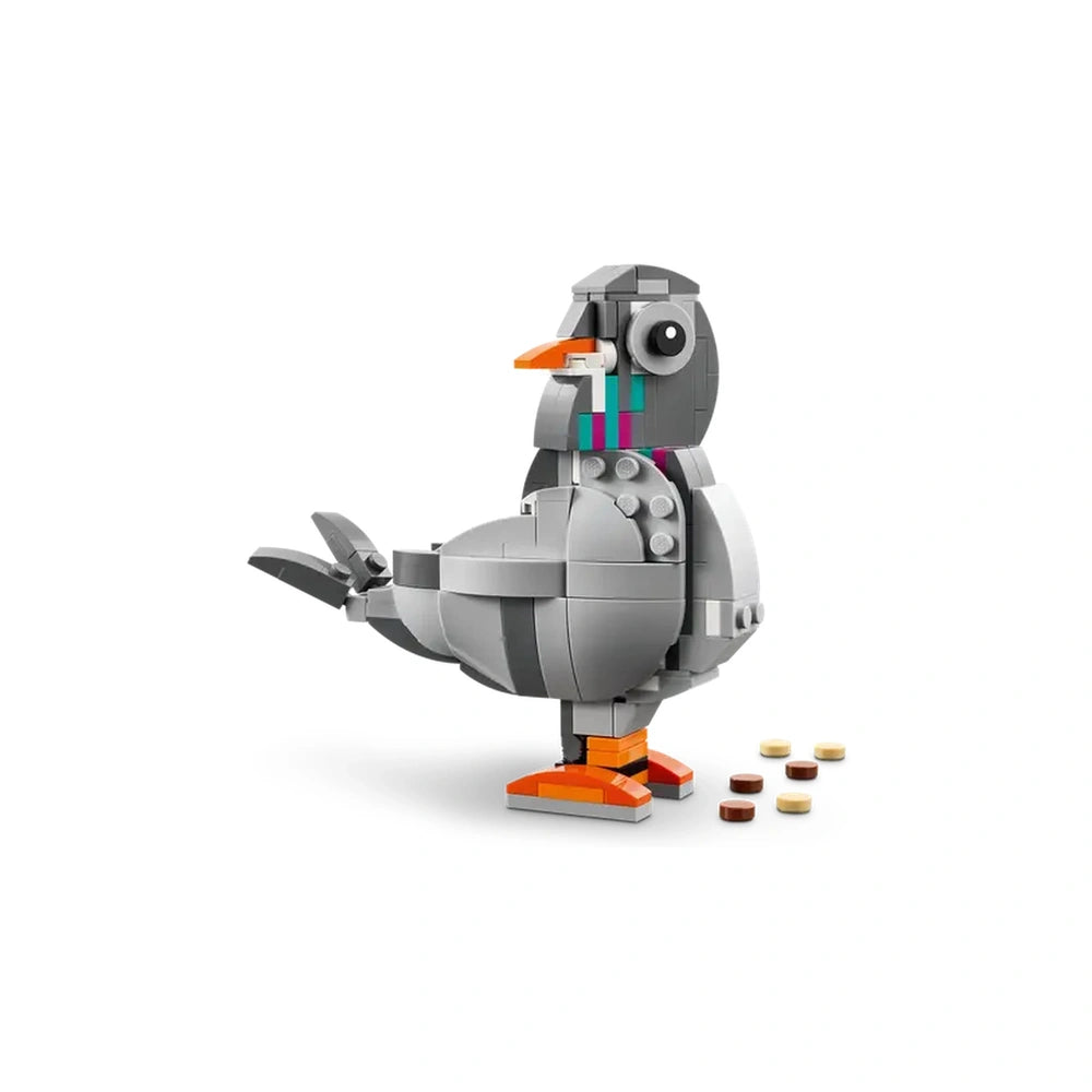 LEGO Creator 3in1 Playful Cat model in gray with vibrant accents like an orange beak and colorful stripes, posed beside small food pieces.