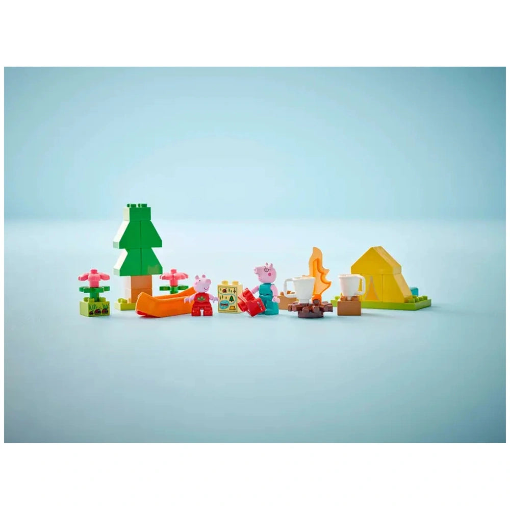 Colorful LEGO® DUPLO® Camping Trip set featuring Peppa Pig, Daddy Pig, a tent, canoe, trees, flowers, and a campfire.