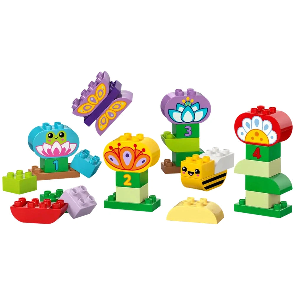 Colorful LEGO® DUPLO® construction set featuring flowers, butterflies, and a smiling bee. Includes numbered flower bases and assorted bricks.