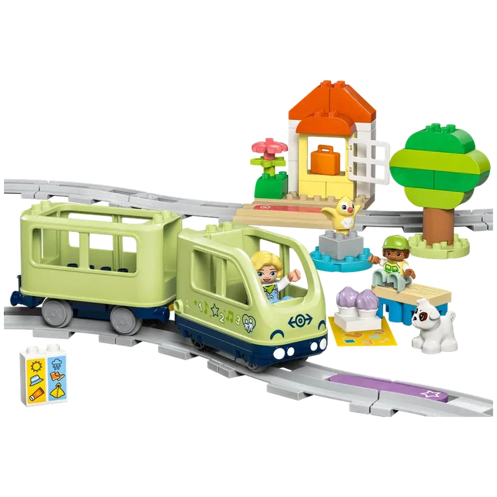 Interactive LEGO® DUPLO® Adventure Train set featuring a green train, two characters, a tree, house, and building bricks, inviting imaginative play.