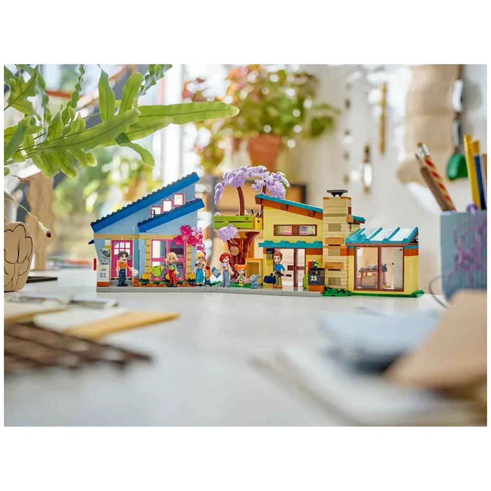 LEGO® Friends construction set featuring two colorful houses and a treehouse, with five mini-dolls and two pets gathered happily in front.