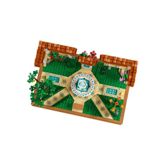 LEGO® Icons Fountain Garden construction set featuring a tiered fountain at the center, surrounded by vibrant flowers and greenery, intricate tile pathways, and charming pergolas with decorative vines.