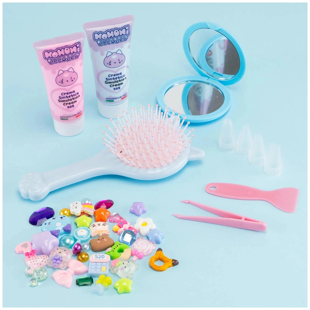Momomi Decoden Kawaii Artist creamy mirror and brush with pink bristles, showcased against a solid light blue background.