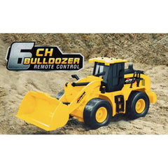 Mondo Motors RC-MX Bulldozer in yellow on brown sand, featuring a large bucket, black seat, and wheels.