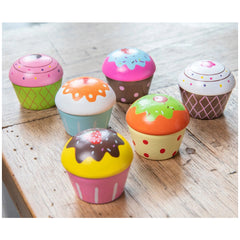 Cupcake assortment in gift box featuring pink, orange, brown, and yellow cupcakes with various icing and sprinkles.