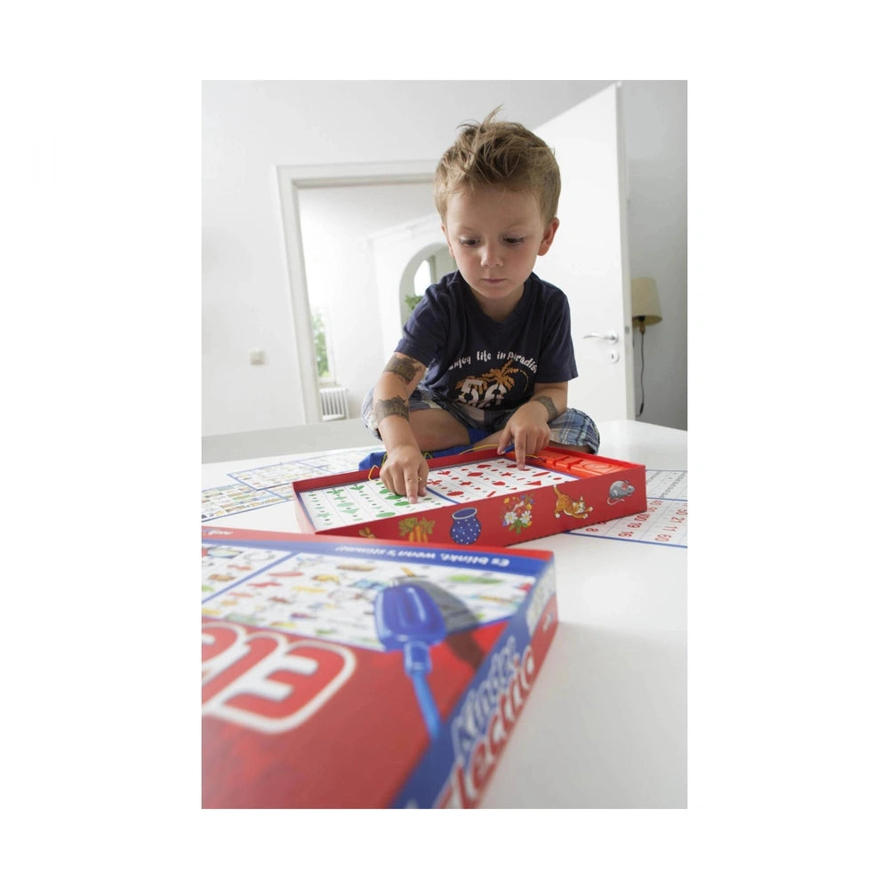 Noris childrens electric board game set with a young child engaged on the floor, surrounded by colorful game pieces and a bri