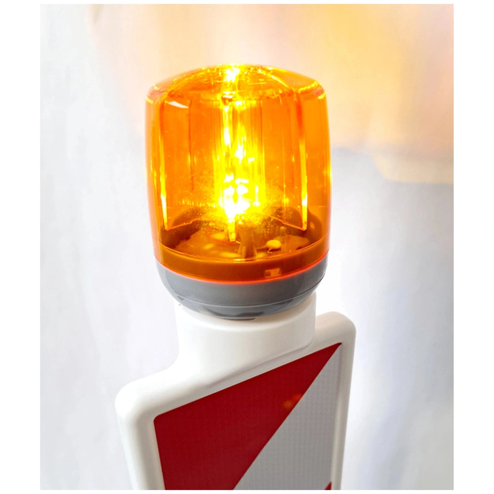 Rollyflashlight accessory features a bright orange light and a red triangle "do not enter" sign on a traffic light pole.