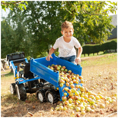 Rollymega Trailer filled with colorful apples, as a young boy smiles while standing on a grassy area.