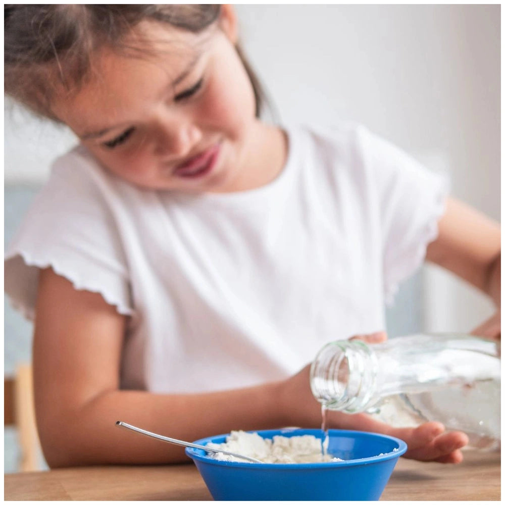 Teifoc well kit featuring a blue bowl and silver spoon, with a girl in the background pouring liquid.