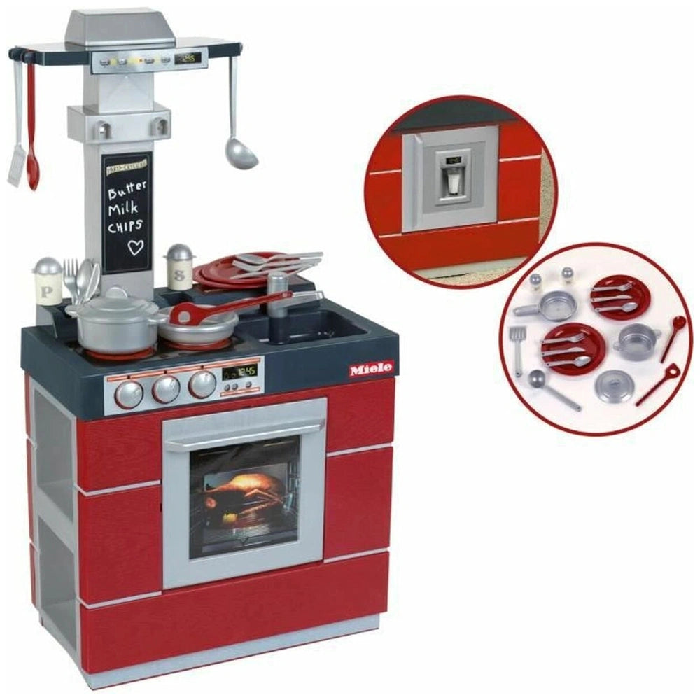 Theo Klein Miele Kitchen Compact features a red oven with black top, glass window, and various silver cooking utensils on the